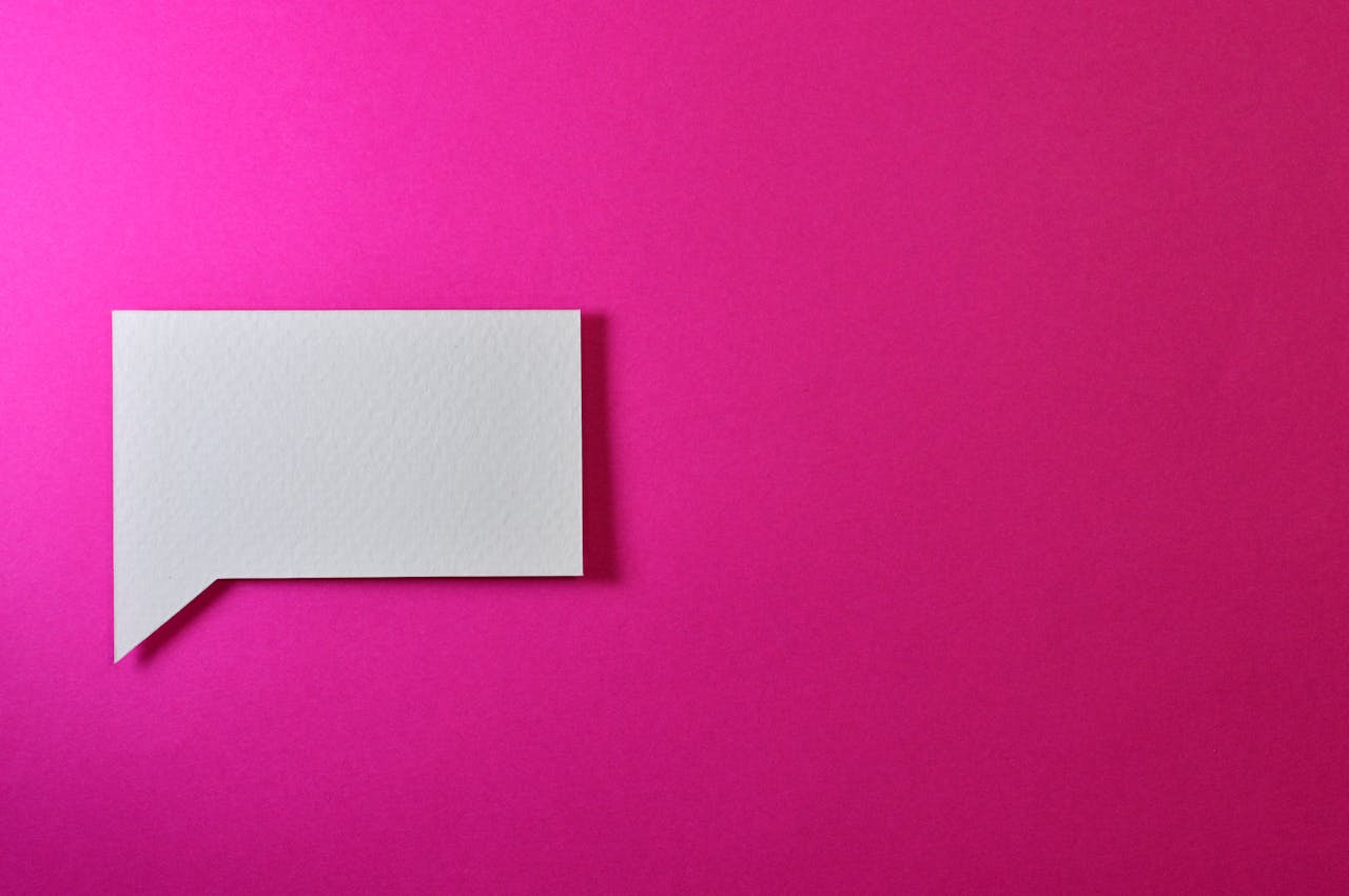 about-01 A minimalistic white paper speech bubble on a vibrant pink background, perfect for design projects.