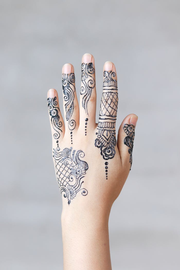 Close-up of an elegant henna mehndi design on a woman's hand, showcasing intricate patterns.